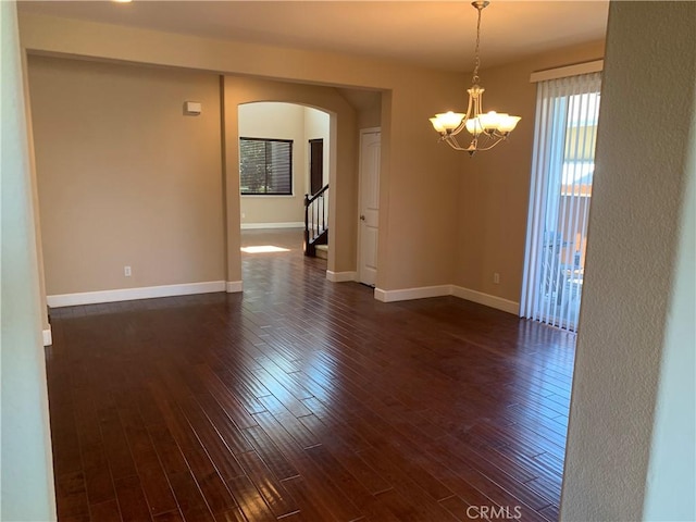 538 Burnt Ranch Way, Chico, CA 95973 - empty room featuring arched walkways, dark wood-type flooring, and a chandelier