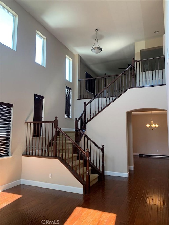538 Burnt Ranch Way, Chico, CA 95973 - stairway featuring a towering ceiling, wood-type flooring, a chandelier, and arched walkways