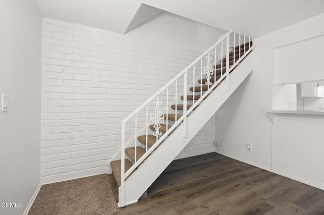 2692 Anchor Ave, Port Hueneme, CA 93041 - stairway with wood finished floors, a textured ceiling, and brick wall