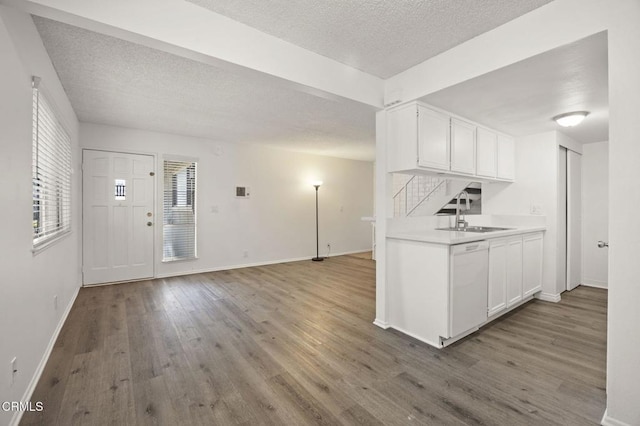 2692 Anchor Ave, Port Hueneme, CA 93041 - kitchen with a textured ceiling, dishwasher, wood finished floors, light countertops, and white cabinetry