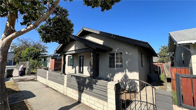 1082 Lewis Ave, Long Beach, CA 90813 - view of front of home with stucco siding, a fenced front yard, and a gate