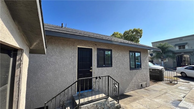 1082 Lewis Ave, Long Beach, CA 90813 - view of exterior entry featuring stucco siding and roof with shingles