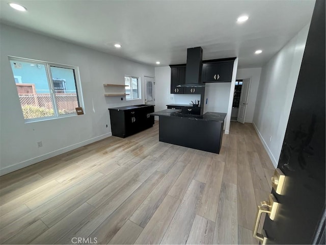 1082 Lewis Ave, Long Beach, CA 90813 - kitchen with wall chimney exhaust hood, a kitchen island, dark cabinets, recessed lighting, and light wood-type flooring