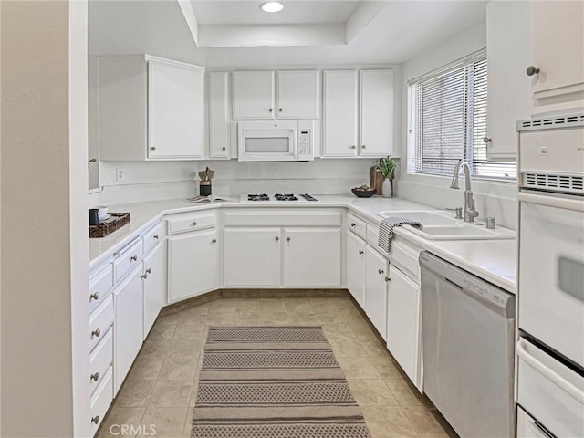 5924 S Pacific Coast Hwy Unit 22, Redondo Beach, CA 90277 - kitchen with white appliances, a sink, a raised ceiling, white cabinets, and light tile patterned floors