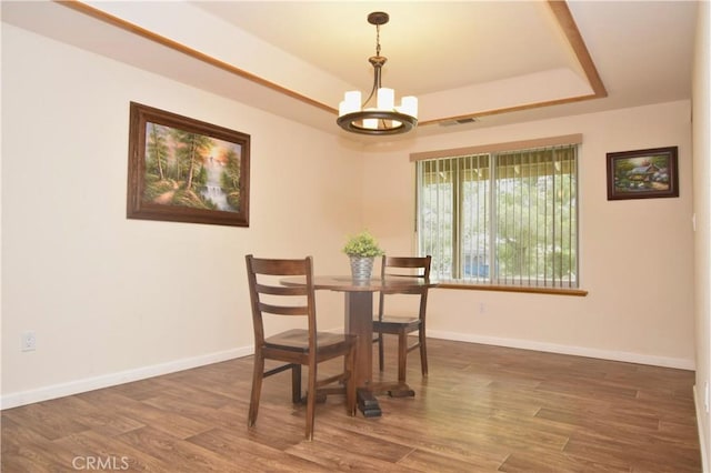 19180 Osceola Rd, Apple Valley, CA 92307 - dining area with a tray ceiling, a chandelier, wood finished floors, and baseboards