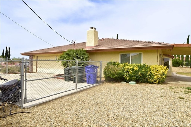 19180 Osceola Rd, Apple Valley, CA 92307 - rear view of property with a gate, a chimney, driveway, and stucco siding