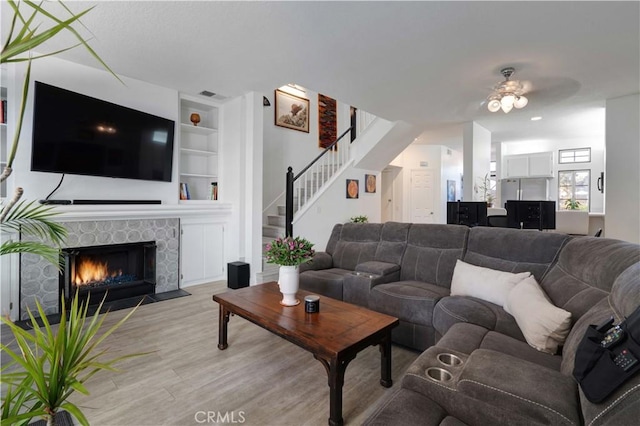 28215 Paseo El Siena Unit 46, Laguna Niguel, CA 92677 - living area featuring built in features, light wood-type flooring, stairs, a ceiling fan, and a fireplace