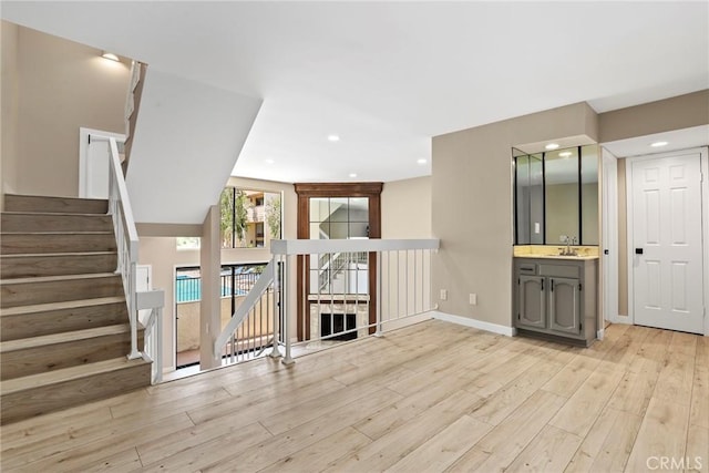 26322 W Bravo Ln, Calabasas, CA 91302 - unfurnished living room with light wood-type flooring, a sink, baseboards, recessed lighting, and stairway
