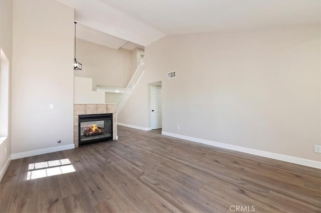 27541 Vanilla Ct, Menifee, CA 92585 - unfurnished living room with wood finished floors, baseboards, a tile fireplace, and high vaulted ceiling