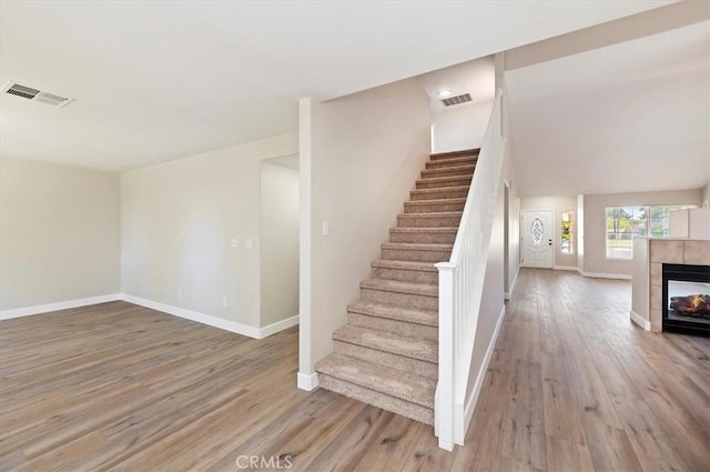27541 Vanilla Ct, Menifee, CA 92585 - staircase with baseboards, wood finished floors, and a tile fireplace