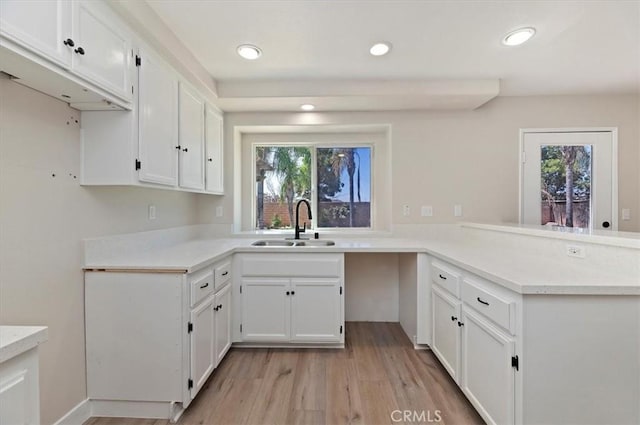 27541 Vanilla Ct, Menifee, CA 92585 - kitchen featuring a sink, a peninsula, white cabinetry, light wood-style floors, and plenty of natural light