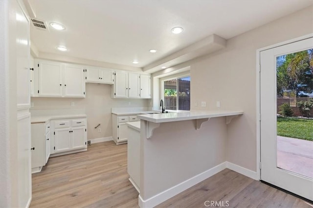 27541 Vanilla Ct, Menifee, CA 92585 - kitchen featuring a peninsula, light wood-style floors, white cabinetry, and recessed lighting