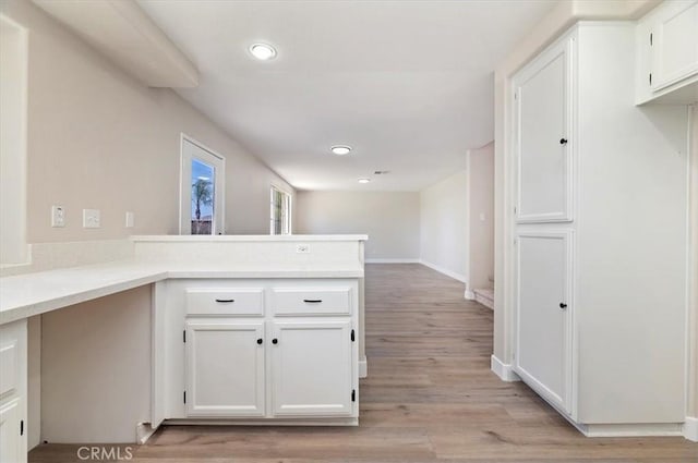 27541 Vanilla Ct, Menifee, CA 92585 - kitchen featuring white cabinets, a peninsula, recessed lighting, light countertops, and light wood-style floors