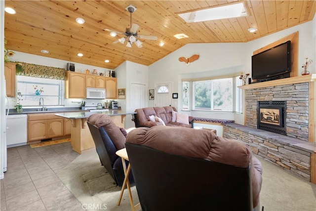 2340 Deep Creek Dr, Running Springs, CA 92382 - living room featuring wood ceiling, healthy amount of natural light, a skylight, a stone fireplace, and a ceiling fan