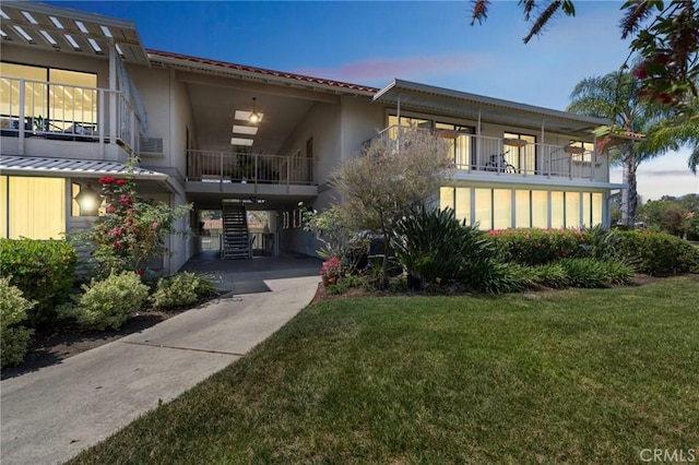 879 Via Mendoza Unit B, Laguna Woods, CA 92637 - view of front of home featuring a yard, stucco siding, and a balcony