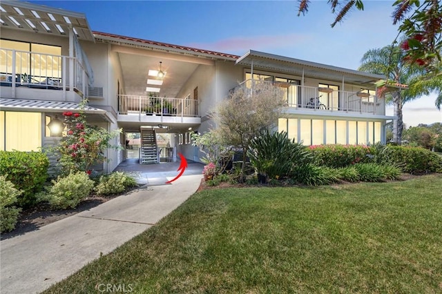 879 Via Mendoza Unit B, Laguna Woods, CA 92637 - view of front of home with stairway, a front yard, and stucco siding