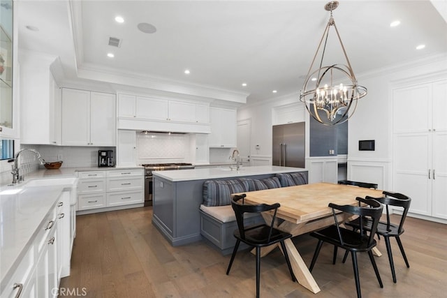 3914 Woodfield Dr, Sherman Oaks, CA 91403 - kitchen with high end appliances, a sink, crown molding, light countertops, and white cabinetry