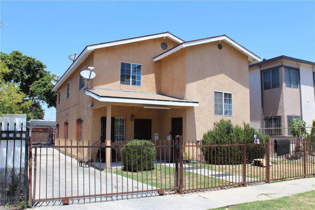 127 E 95th St, Los Angeles, CA 90003 - view of front of house with stucco siding, a fenced front yard, and a gate