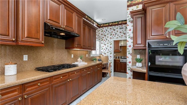2225 Wind River Ln, Rowland Heights, CA 91748 - kitchen featuring under cabinet range hood, black gas stovetop, wallpapered walls, and decorative backsplash