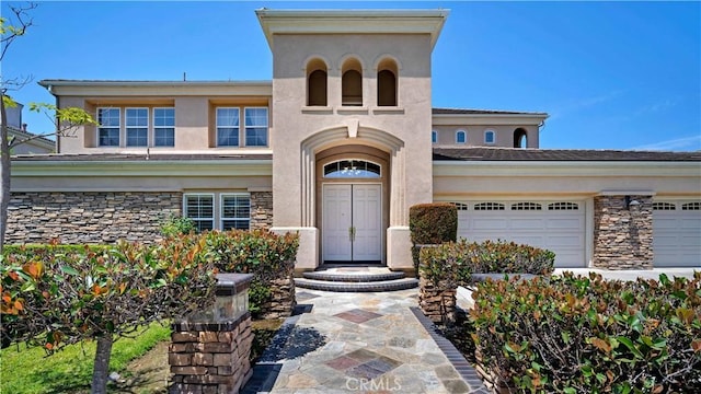 2225 Wind River Ln, Rowland Heights, CA 91748 - entrance to property featuring an attached garage, stucco siding, and stone siding