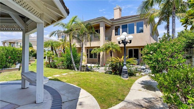 2225 Wind River Ln, Rowland Heights, CA 91748 - rear view of property with stucco siding, a yard, a balcony, and a chimney