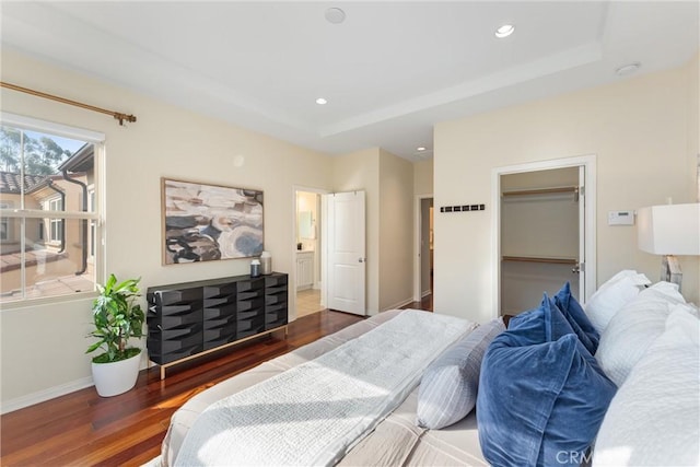 33 Lacebark, Irvine, CA 92618 - bedroom with wood finished floors, recessed lighting, baseboards, a tray ceiling, and a walk in closet