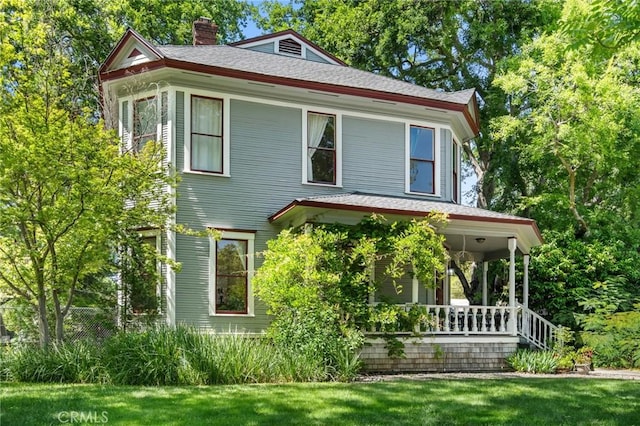 256 E 1st Ave, Chico, CA 95926 - victorian house featuring a chimney, covered porch, a shingled roof, and a front lawn