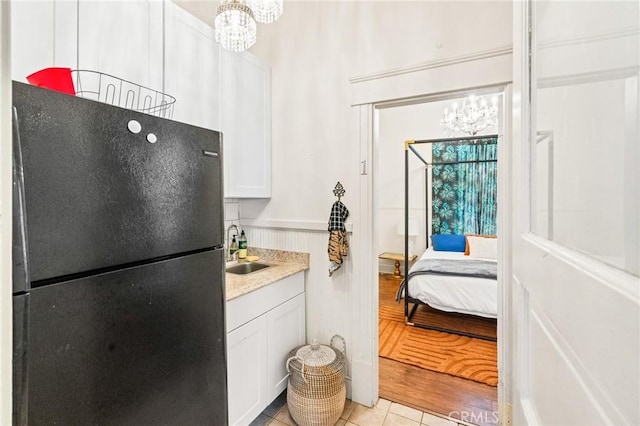 256 E 1st Ave, Chico, CA 95926 - kitchen featuring freestanding refrigerator, a chandelier, a sink, and light tile patterned flooring