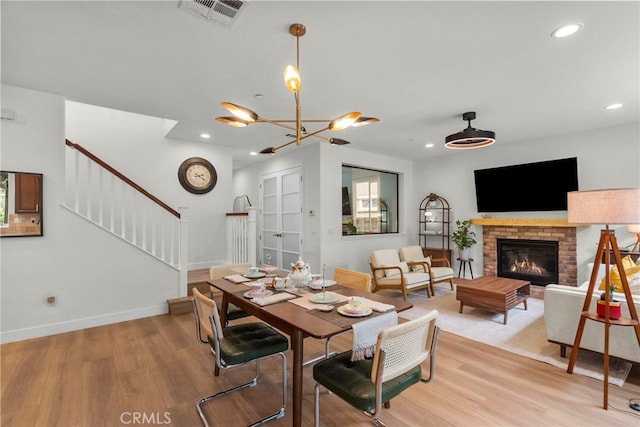 28321 Esplanada Dr, Valencia, CA 91354 - dining room featuring light wood-style flooring, stairs, recessed lighting, baseboards, and a fireplace