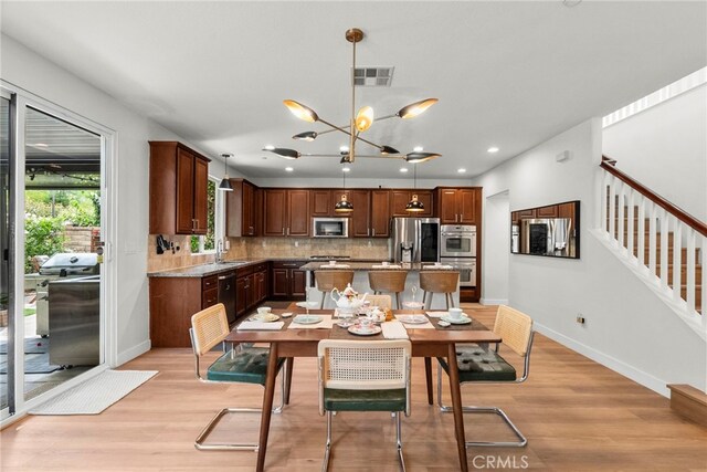 28321 Esplanada Dr, Valencia, CA 91354 - dining area with baseboards, light wood-style floors, a chandelier, recessed lighting, and stairs