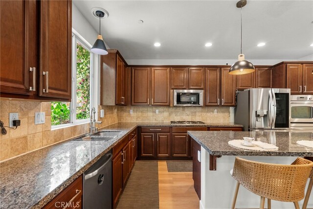 28321 Esplanada Dr, Valencia, CA 91354 - kitchen featuring appliances with stainless steel finishes, a sink, a kitchen bar, recessed lighting, and light wood-style flooring