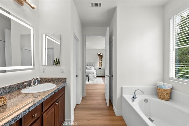 28321 Esplanada Dr, Valencia, CA 91354 - ensuite bathroom with vanity, a garden tub, healthy amount of natural light, and wood finished floors