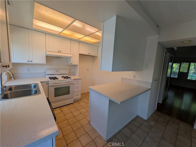 1266 Tarryglen Ln, San Dimas, CA 91773 - kitchen featuring white range with gas cooktop, a sink, under cabinet range hood, white cabinetry, and light countertops
