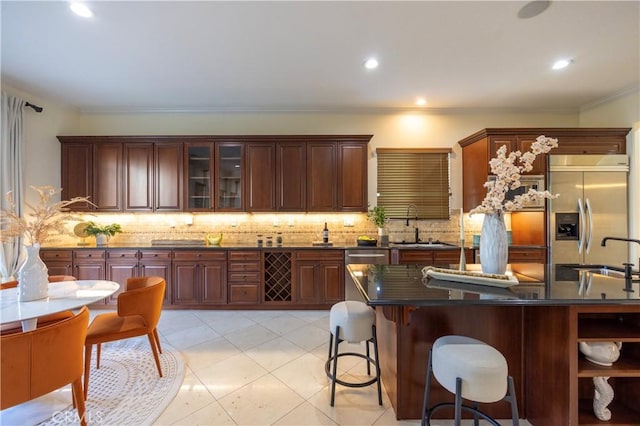 12920 Evermay Ct, Rancho Cucamonga, CA 91739 - kitchen with appliances with stainless steel finishes, dark countertops, crown molding, decorative backsplash, and a sink