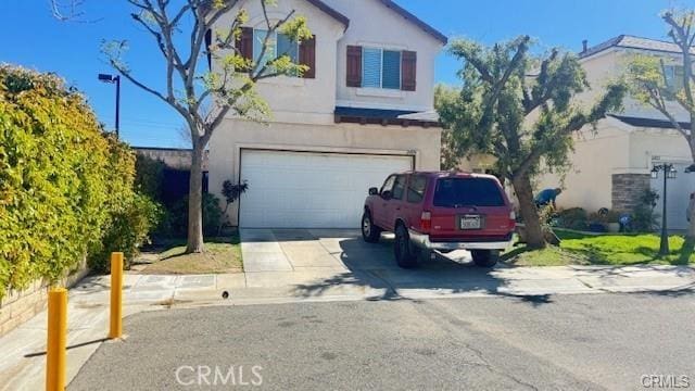 24854 Noelle Way, Newhall, CA 91321 - view of front of property featuring stucco siding, a garage, and concrete driveway