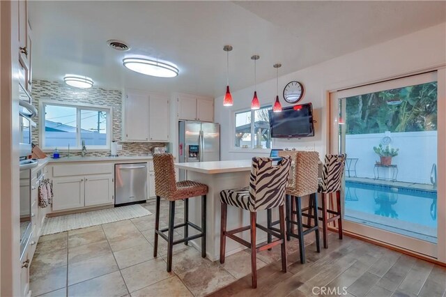 1717 Cumbre Dr, San Pedro, CA 90732 - kitchen featuring stainless steel appliances, plenty of natural light, light countertops, and white cabinets