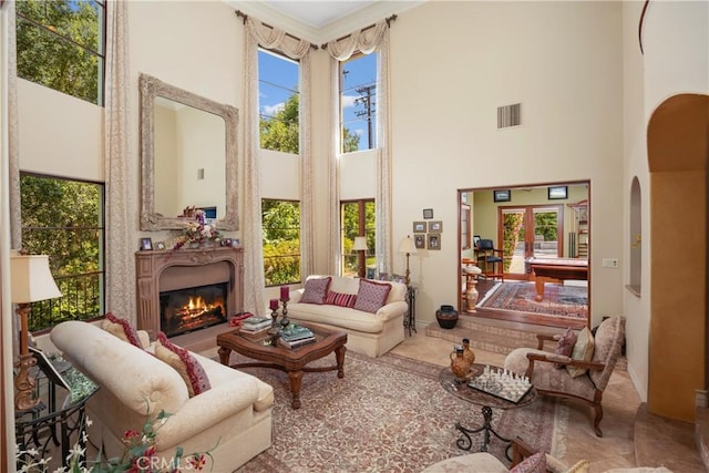 4204 Woodleigh Ln, La Canada Flintridge, CA 91011 - living area with a high ceiling, arched walkways, a glass covered fireplace, and healthy amount of natural light