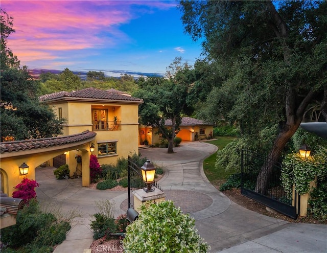 4204 Woodleigh Ln, La Canada Flintridge, CA 91011 - mediterranean / spanish house with curved driveway, stucco siding, a tiled roof, and a balcony