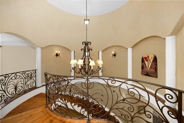 4204 Woodleigh Ln, La Canada Flintridge, CA 91011 - stairs with a chandelier, arched walkways, wood finished floors, a towering ceiling, and ornate columns