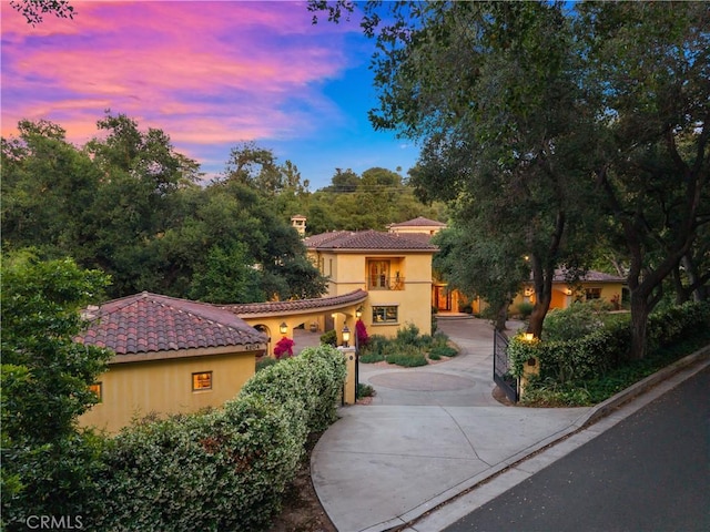 4204 Woodleigh Ln, La Canada Flintridge, CA 91011 - mediterranean / spanish-style house featuring stucco siding, a tile roof, and curved driveway