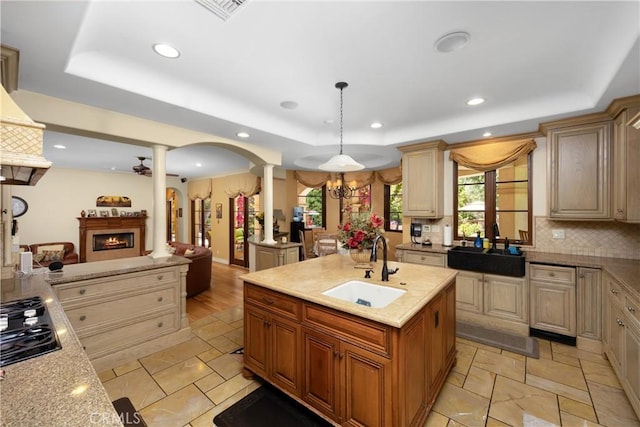 4204 Woodleigh Ln, La Canada Flintridge, CA 91011 - kitchen featuring ornate columns, a sink, a raised ceiling, a lit fireplace, and recessed lighting