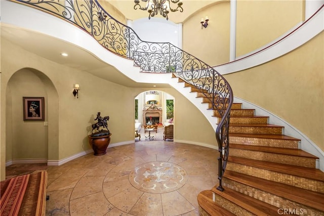 4204 Woodleigh Ln, La Canada Flintridge, CA 91011 - tiled entryway featuring arched walkways, inlaid floor details, baseboards, stairs, and a high ceiling