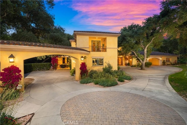 4204 Woodleigh Ln, La Canada Flintridge, CA 91011 - mediterranean / spanish-style home with curved driveway, stucco siding, a balcony, and a tile roof