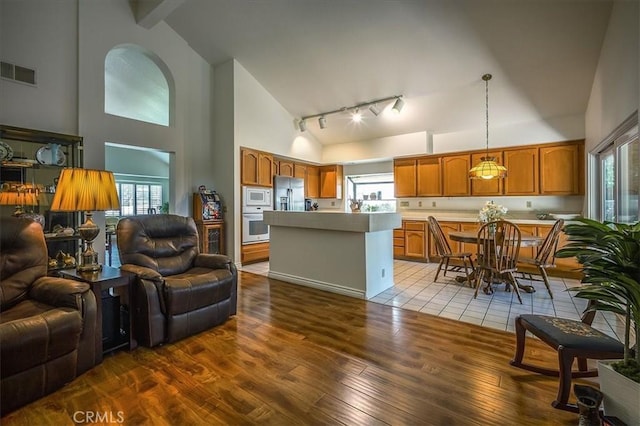 960 Via Serana, Upland, CA 91784 - living room with high vaulted ceiling, wood-type flooring, healthy amount of natural light, and track lighting