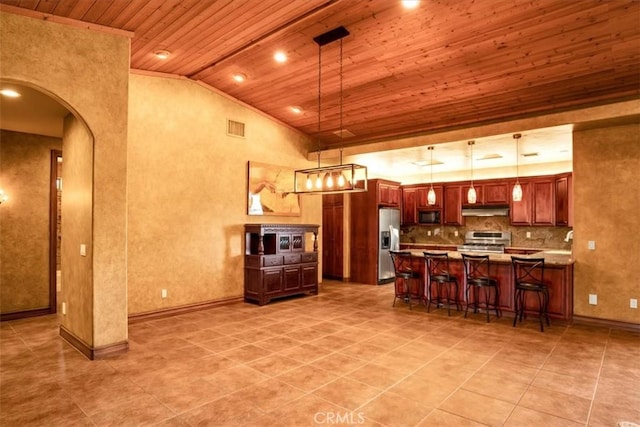57934 Juarez Dr, Yucca Valley, CA 92284 - kitchen featuring wood ceiling, stainless steel appliances, under cabinet range hood, lofted ceiling, and a kitchen bar