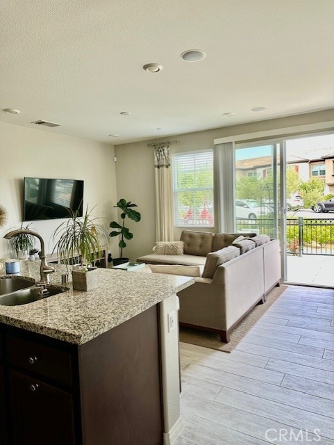 40265 Calle Real, Murrieta, CA 92563 - kitchen featuring open floor plan, a sink, light wood-style flooring, and light stone counters