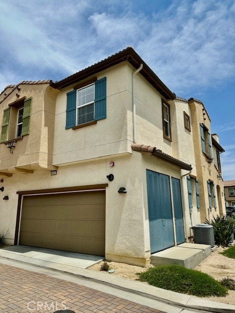 40265 Calle Real, Murrieta, CA 92563 - view of front facade featuring central AC, stucco siding, an attached garage, and a tile roof