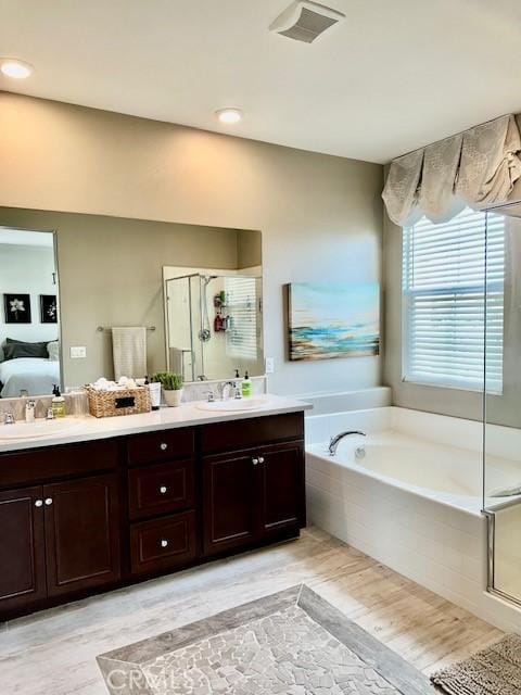 40265 Calle Real, Murrieta, CA 92563 - ensuite bathroom featuring a bath, double vanity, a stall shower, and wood finished floors