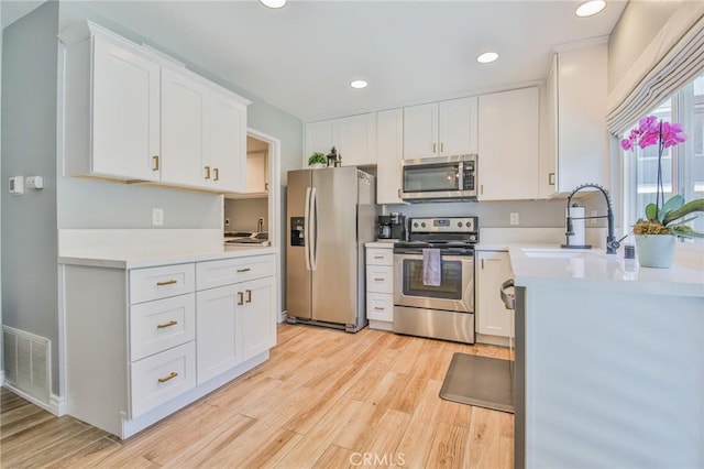 5427 E Pine Ridge Way Unit D, Anaheim, CA 92807 - kitchen featuring stainless steel appliances, light wood-style flooring, light countertops, white cabinetry, and recessed lighting
