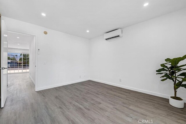 20930 Parthenia St Unit 206, Canoga Park, CA 91304 - unfurnished room featuring a wall unit AC, wood finished floors, recessed lighting, and baseboards